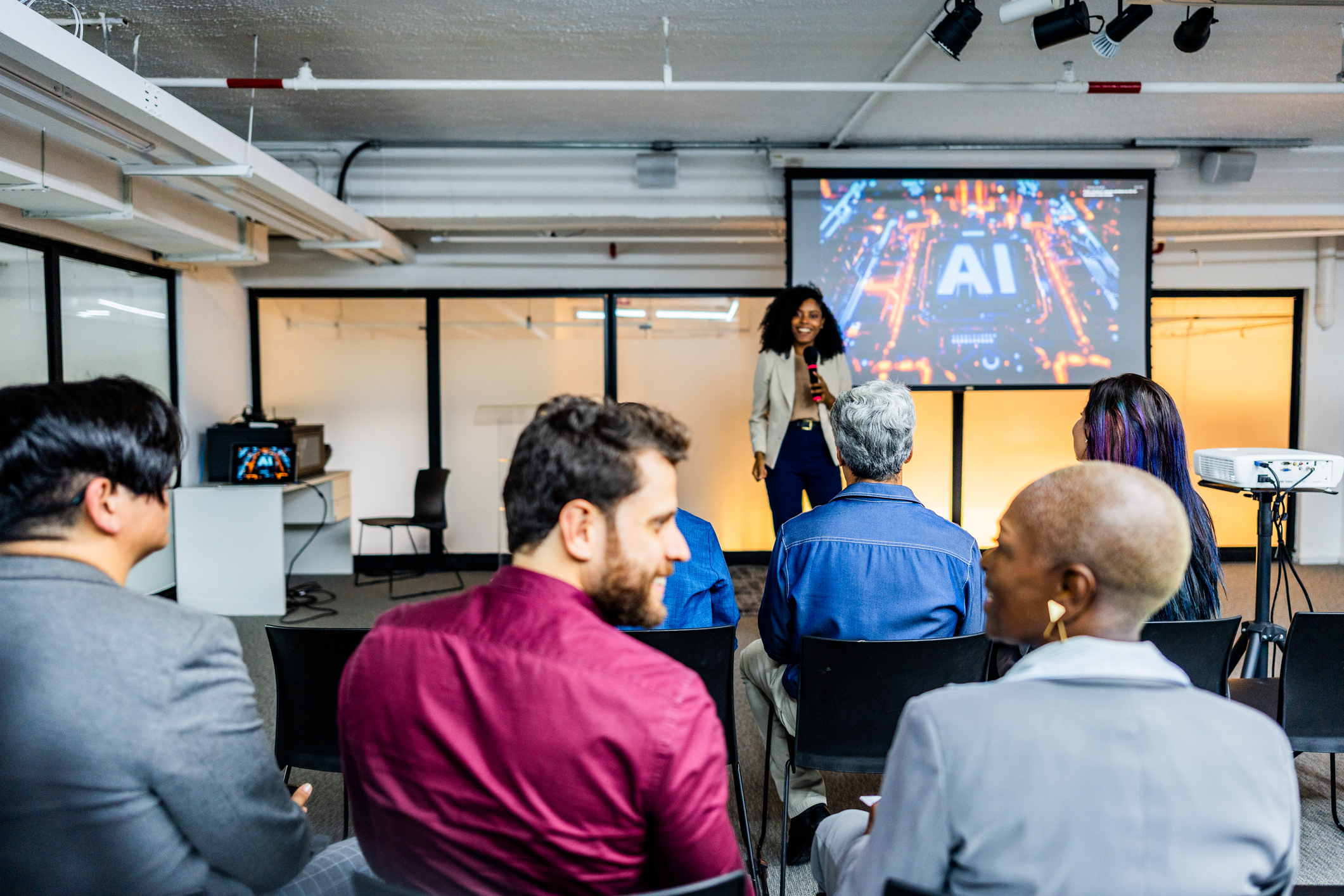 Diverse group of coworkers attending AI presentation in office