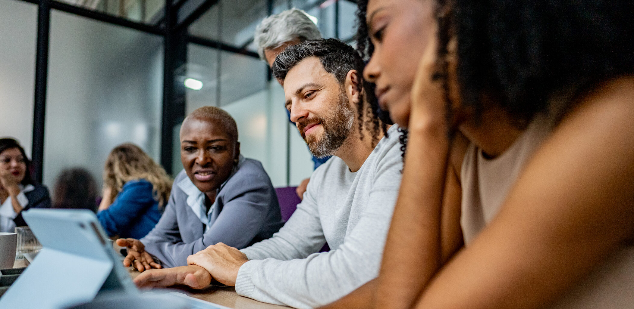 Coworkers using digital tablet during business meeting at office